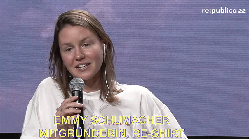 Emmy Schumacher hält einen Vortrag und hat ein Mikrofon in der Hand