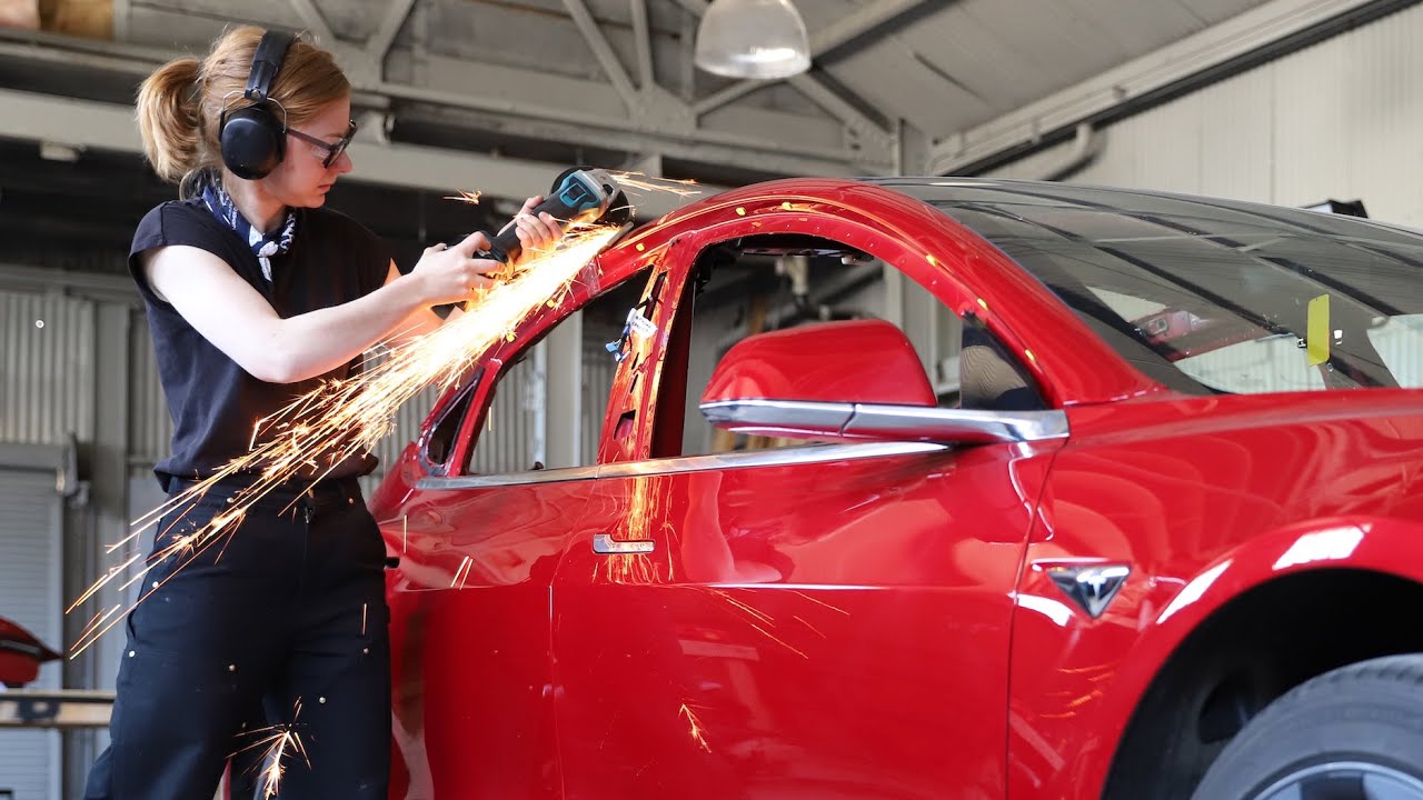 Simone Giertz beim flexen eines roten Autos