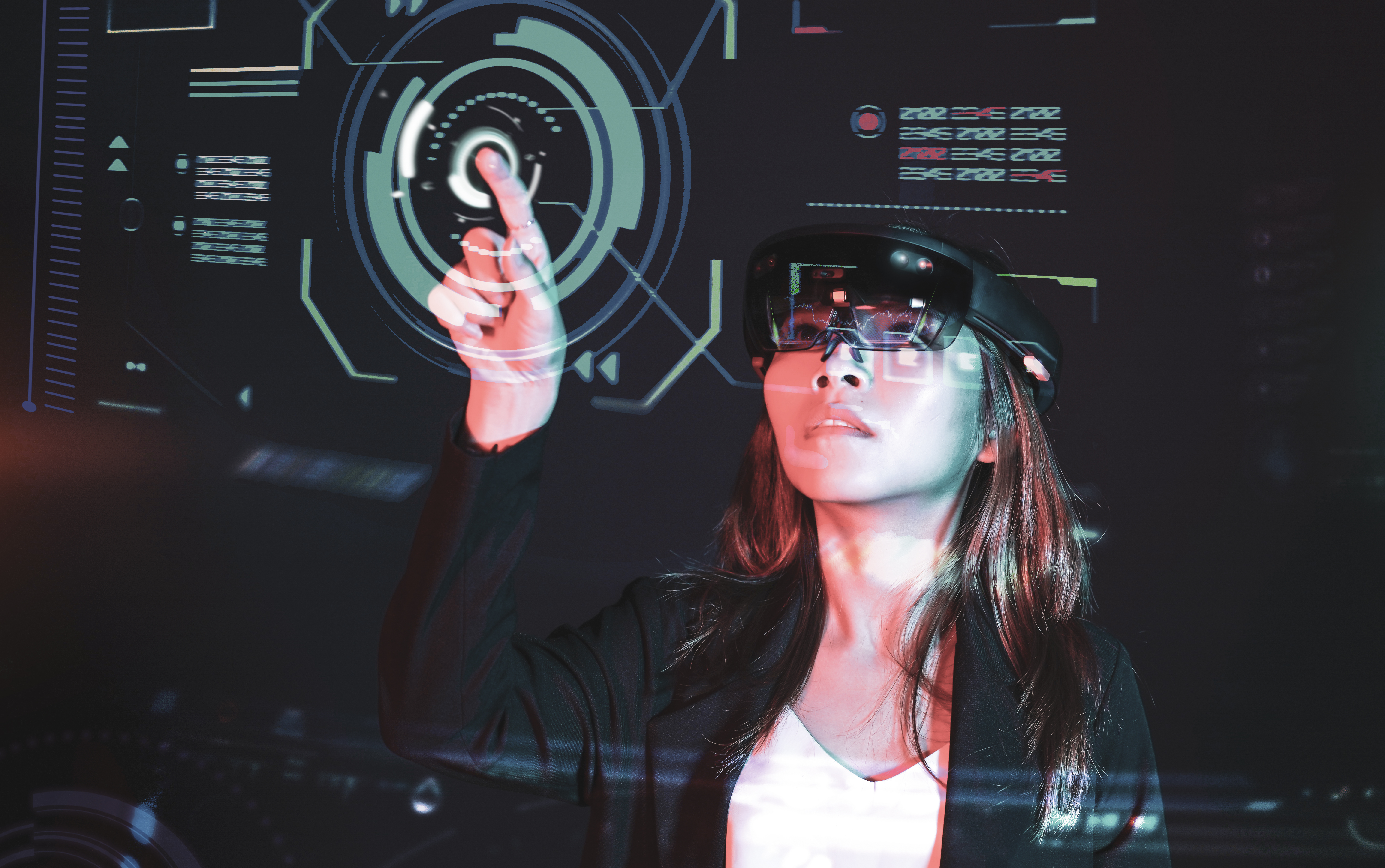 Frau mit einer VR Brille steht vor einem digitalen Touchscreen